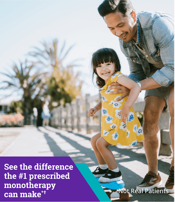 Man holding small child on the sidewalk as both smile